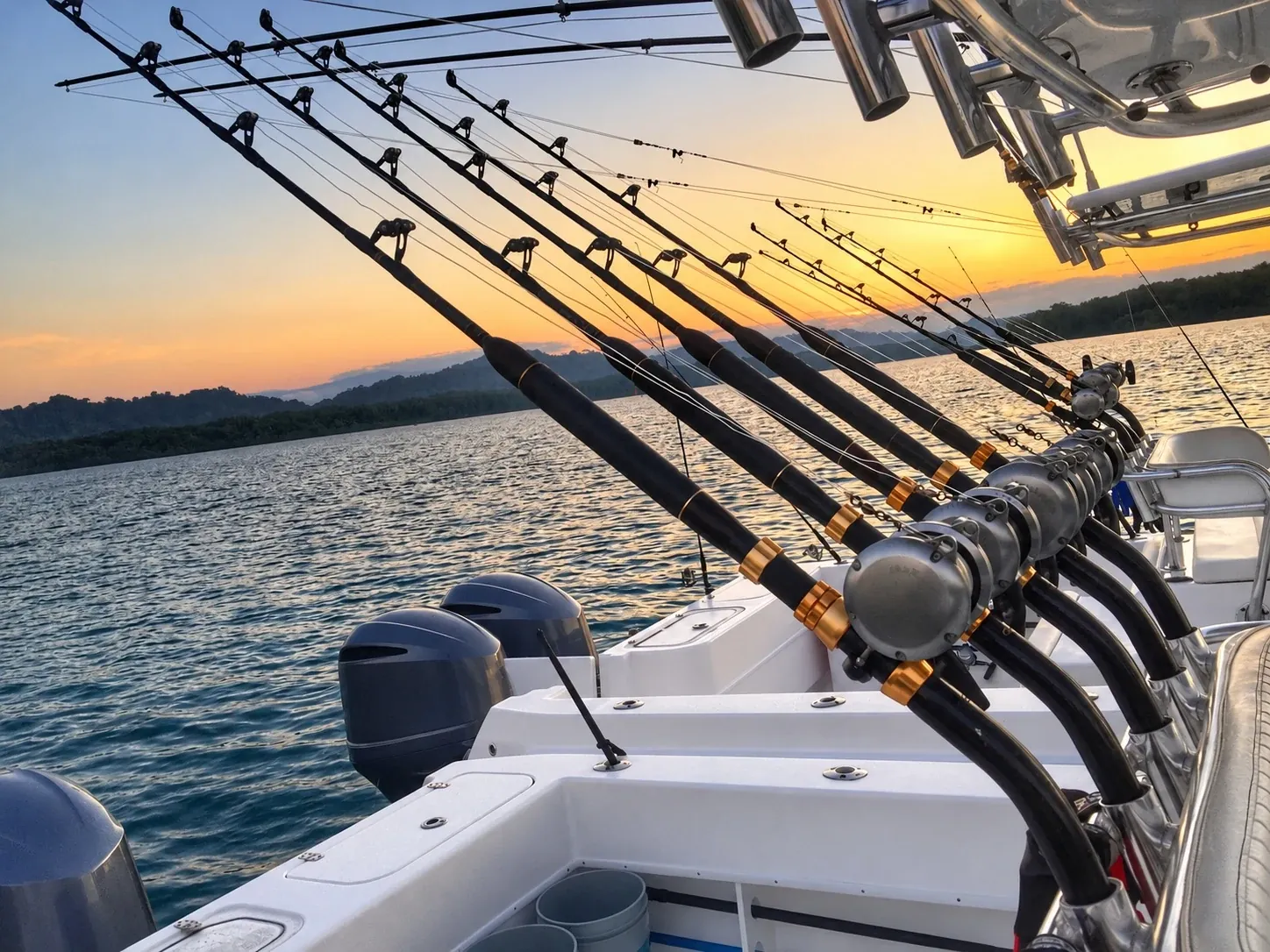 Cañas de pesca a bordo de una embarcación al atardecer